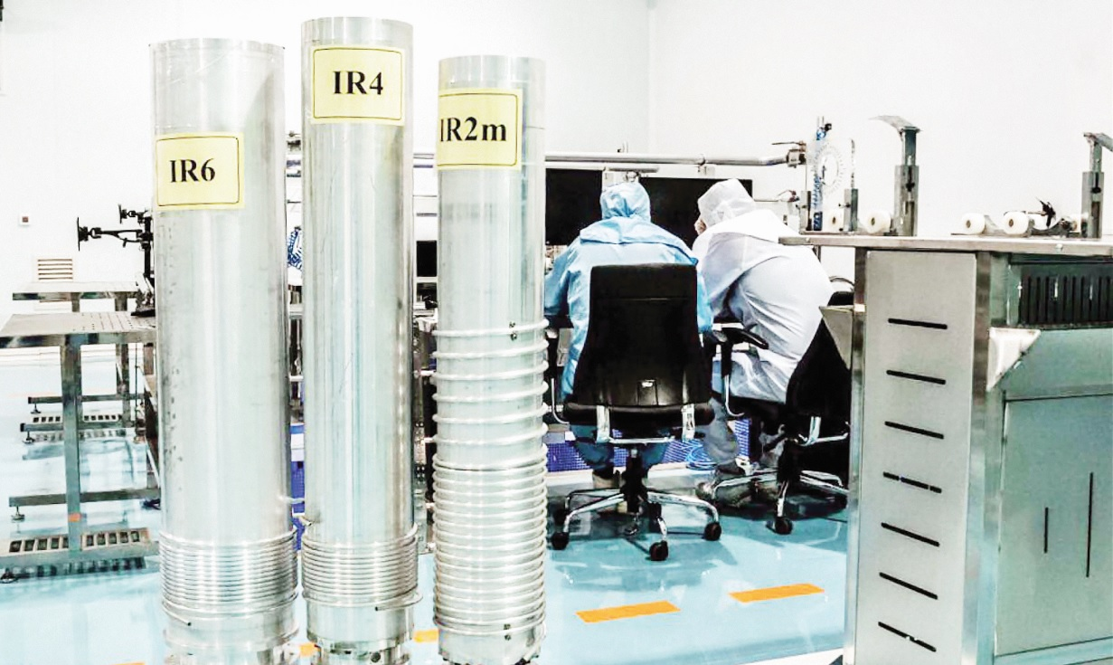 Three different Iranian centrifuges in front of people in blue scrubs